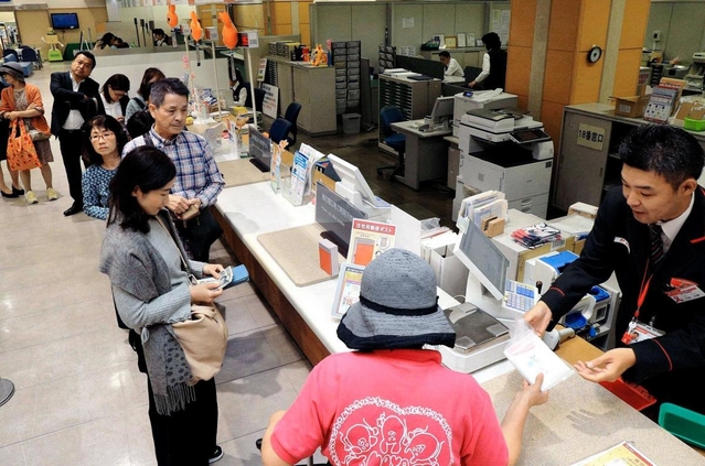 年賀状の購入に列をつくる人たち。一部の企業などには年内に届く＝神戸市中央区栄町通６、神戸中央局