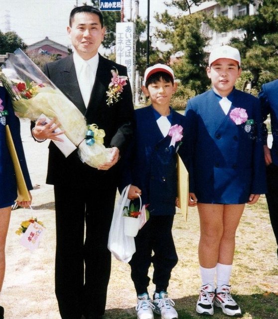 白浜小学校の卒業式で記念写真に収まる内海崇さん（右）と寺前直一さん（左）＝姫路市白浜町（寺前さん提供）