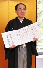 就位状を手に笑顔を見せる木村一基王位＝日比谷松本楼