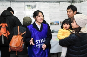 阪神・淡路大震災当時の状況を来場者に説明する舞子高校環境防災科の生徒＝６日夜、神戸市中央区加納町６、東遊園地（撮影・後藤亮平）