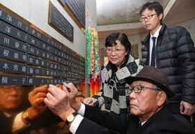 芦屋市の自宅で亡くなった弟今村幸司さんのプレートを取り付ける憲司さん＝１４日午後、神戸市中央区加納町６（撮影・吉田敦史）