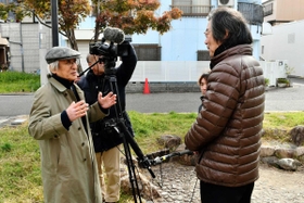 海運双子池公園で建築家の森崎輝行さんにインタビューする青池憲司監督（左）＝神戸市長田区海運町３