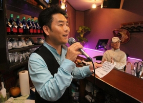 永遠鉄道を練習する歌手の岡田ひさしさん＝神戸市垂水区日向２、カラオケ喫茶マリアッチ