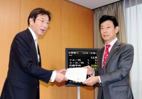 西村康稔担当相（右）に共同宣言を手渡した久元喜造神戸市長＝１９日午後、東京都千代田区