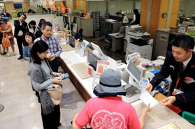 年賀状の購入に列をつくる人たち。一部の企業などには年内に届く＝神戸市中央区栄町通６、神戸中央局