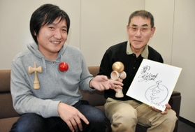 内海崇さんのサイン色紙とプレゼントのけん玉を持つ恩師の寺前直一さん（右）と幼なじみの中村伊織さん＝姫路市豊沢町、神戸新聞姫路本社