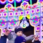 色鮮やかな光の中を肩車して歩く親子＝６日夜、神戸市中央区加納町６（撮影・秋山亮太）