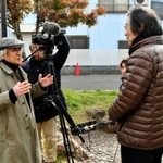 海運双子池公園で建築家の森崎輝行さんにインタビューする青池憲司監督（左）＝神戸市長田区海運町３