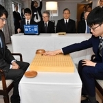 天元戦第５局で初手を打つ許家元八段（右）。左は井山裕太天元＝１８日午前、徳島市、徳島グランヴィリオホテル