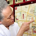 湊川神社の最寄り駅、市営地下鉄大倉山駅を示す権宮司の西原秀樹さん＝神戸市中央区多聞通３