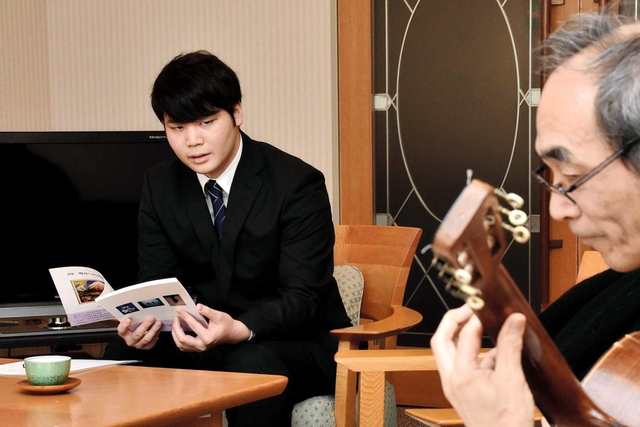 ギター奏者と朗読の練習をする関西学院大３年の江口仁さん＝神戸市東灘区本庄町１、神戸レインボーハウス