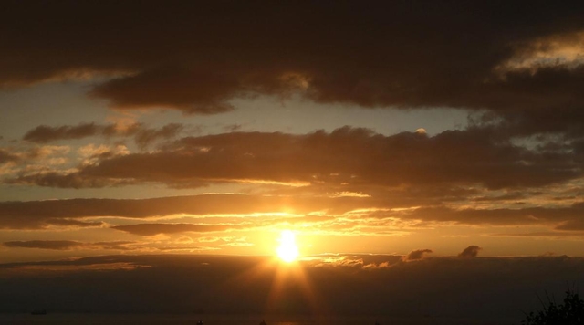 太陽柱（サンピラー）のような光を放った後、雲の間から現れた太陽＝５日午前７時１８分、神戸市須磨区から大阪湾岸方面を望む