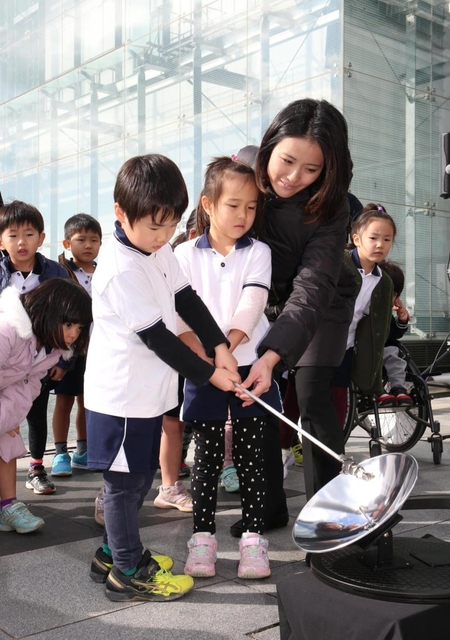 太陽光を集める装置で採火を試みる園児ら＝９日午後、神戸市中央区脇浜海岸通１（撮影・辰巳直之）
