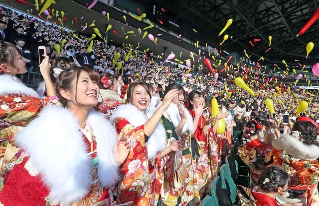 甲子園球場での成人式で、ジェット風船を飛ばす新成人＝１３日午後、西宮市甲子園町（撮影・風斗雅博）