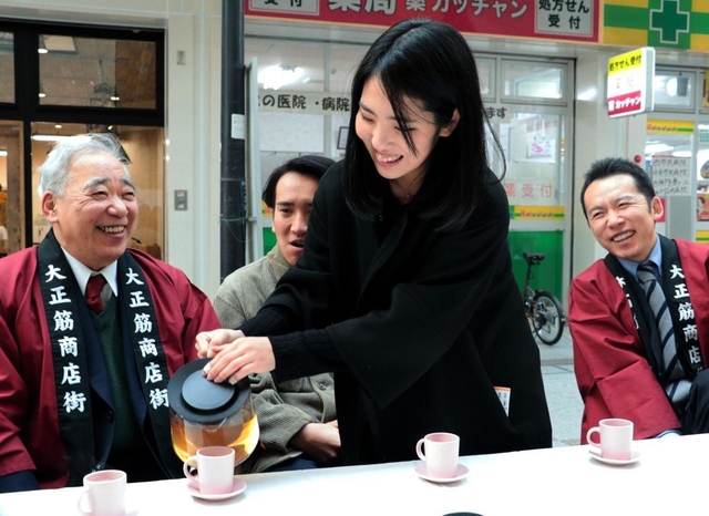 震災の経験を商店主から聞く長谷川紗椰香さん（右から２人目）＝１７日午後２時１３分、神戸市長田区、大正筋商店街