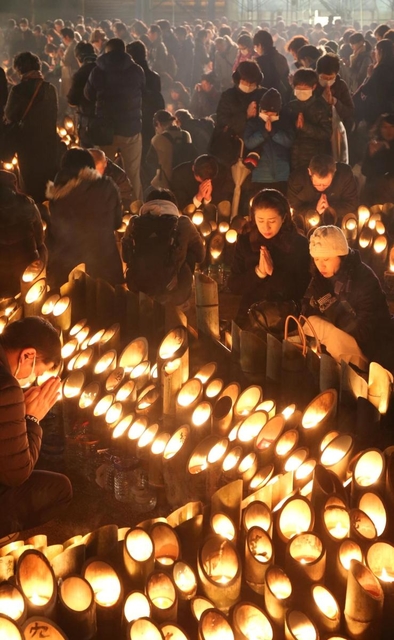 追悼の人波は夜になっても途切れず。夕方の５時４６分に黙とうをささげる人たち＝１７日午後５時４６分、神戸市中央区加納町６（撮影・小林良多）
