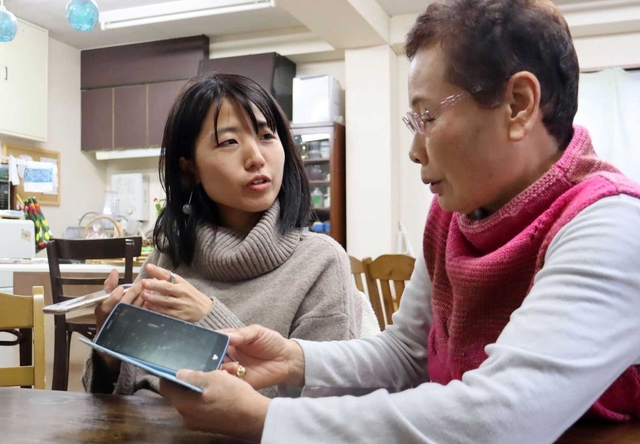 スマートフォンを片手に交流を深める高齢者と大学生＝神戸市須磨区須磨浦通３