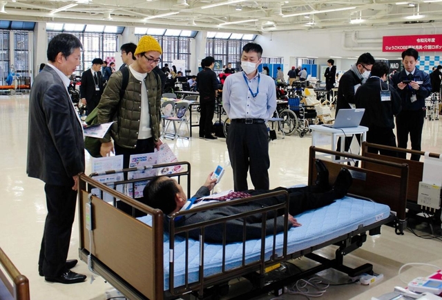 展示された福祉用具について説明を受ける来場者＝神戸市中央区浜辺通５