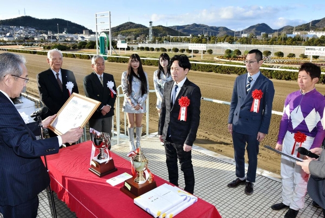 表彰式で高梨柳太郎社長（左）から賞状を受け取る青山裕一さん（中央）＝姫路競馬場