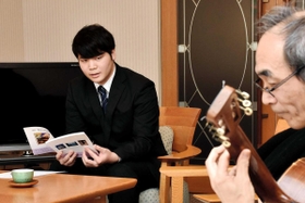 ギター奏者と朗読の練習をする関西学院大３年の江口仁さん＝神戸市東灘区本庄町１、神戸レインボーハウス