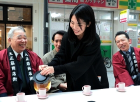 震災の経験を商店主から聞く長谷川紗椰香さん（右から２人目）＝１７日午後２時１３分、神戸市長田区、大正筋商店街