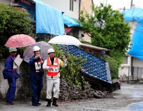 熊本地震の被災地で、派遣職員として家屋被害認定調査に当たる淡路市の職員（右）＝２０１６年５月、熊本県益城町