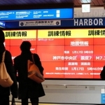 訓練用の地震情報が映し出されたデジタルサイネージ（電子看板）を見つめる人たち＝１７日午前９時６分、神戸市中央区東川崎町１（撮影・大山伸一郎）