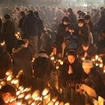 追悼の人波は夜になっても途切れず。夕方の５時４６分に黙とうをささげる人たち＝１７日午後５時４６分、神戸市中央区加納町６（撮影・小林良多）