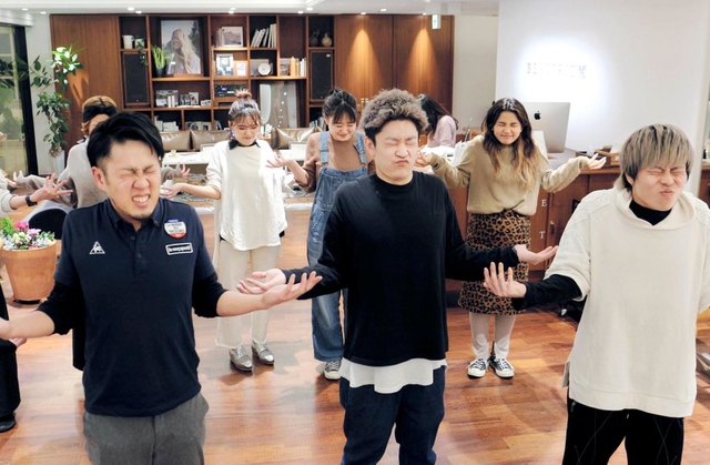 美容師たちに肩凝り改善のストレッチを指導するトレーナーの長野憲次さん（手前左）＝神戸市中央区