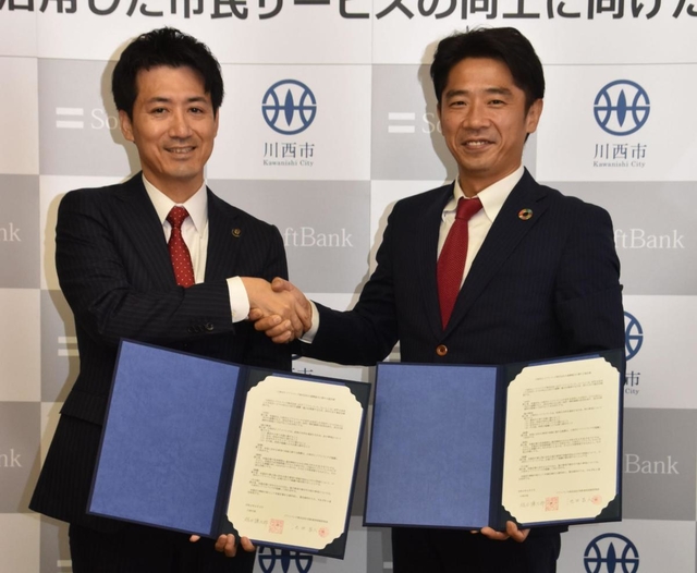 協定書を交わす川西市の越田謙治郎市長（左）とソフトバンクの池田昌人統括部長＝川西市役所