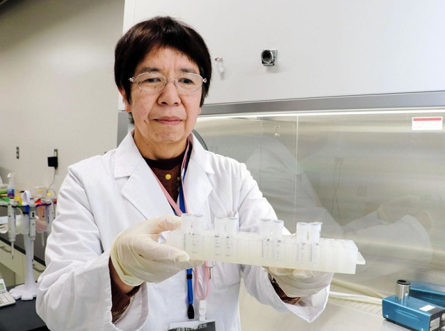 新型コロナウイルス用の試薬を手にする秋山由美感染症部長＝県立健康科学研究所