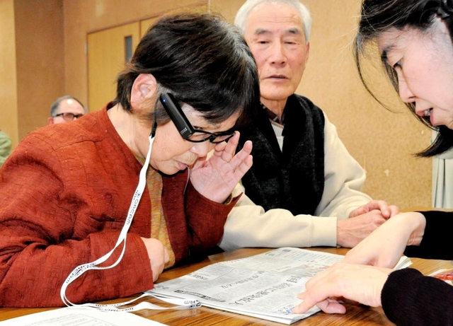 眼鏡に取り付けた視覚支援機器で、新聞の読み取りを体験する参加者＝丹波篠山市、丹南健康福祉センター