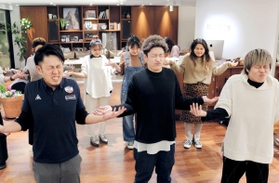 美容師たちに肩凝り改善のストレッチを指導するトレーナーの長野憲次さん（手前左）＝神戸市中央区