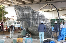 鉄筋の骨組みに生コンクリートを注入される新たなカエルの滑り台＝神戸市須磨区北町１