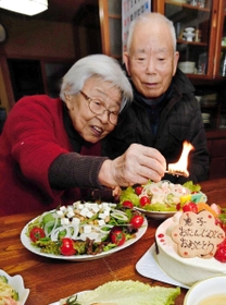 北朝鮮に拉致された有本恵子さんの５７歳の誕生日を祝うケーキに火をともす、有本明弘さん（右）、嘉代子さん夫妻＝２０１７年１月１２日、神戸市長田区
