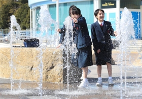 陽気の下、噴水の水に触れてはしゃぐ中学生ら＝１３日午後、神戸市中央区波止場町