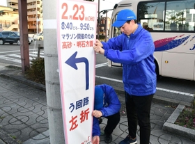姫路城マラソンの中止決定を受け、案内看板を撤去する大会関係者ら＝１９日午後、姫路市内（撮影・谷川直生）