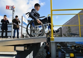 車両に見立てた台車（右）に向け、自動で板が伸びる段差解消装置＝２１日午前、三田市福島