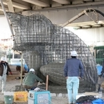 鉄筋の骨組みに生コンクリートを注入される新たなカエルの滑り台＝神戸市須磨区北町１