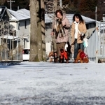 雪化粧した道を散歩する人たち＝６日午前、神戸市北区花山中尾台３（撮影・斎藤雅志）