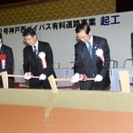 工事の安全と早期開通を願い、くわ入れを行う関係者ら＝１６日午後、神戸市西区平野町宮前