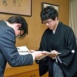 日本棋院の小林覚理事長（左）から允許状を受け取る井山裕太天元＝東京都千代田区、日本棋院