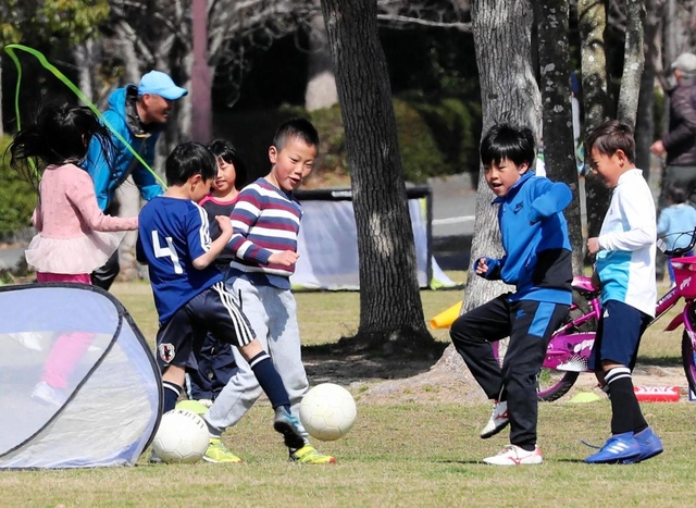 臨時休校措置後初めての週末を迎え、外出を控えていた子どもらは広場を元気に駆け回った＝７日午前、神戸市北区しあわせの村