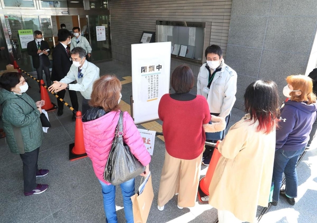 兵庫区役所が閉鎖され、入口前で対応する職員ら＝９日午前１０時３５分、神戸市兵庫区荒田町１、兵庫区役所（撮影・大森　武）