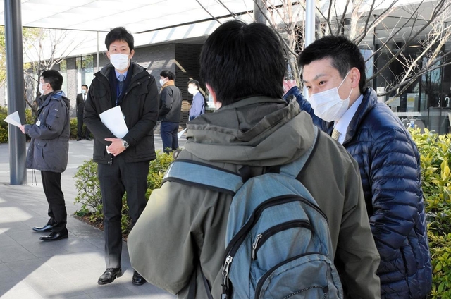 外来で訪れた患者に事情を説明する構成市の職員ら＝１２日午前、小野市市場町、北播磨総合医療センター