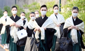 マスクを付け会場に向かう宝塚音楽学校の卒業生たち＝宝塚音楽学校（撮影・山口登）