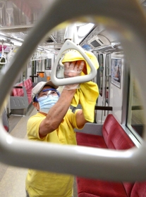 次亜塩素酸水を吹き付けた布でつり革や手すりを消毒する作業員＝４日午後、神戸市兵庫区御崎町１、神戸市営地下鉄御崎車庫