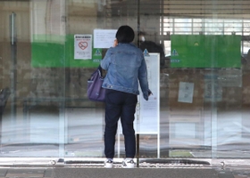 勤務する看護師が新型コロナウイルスに感染していたことが分かり、閉鎖を伝える紙が張り出された仁恵病院玄関。来院した人が困惑した様子で電話していた＝８日午前１０時４４分、姫路市野里