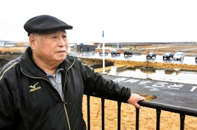 津波にさらわれた店の跡地周辺に立つ尾形勝壽さん＝８日午後、宮城県石巻市門脇町５