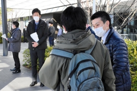 外来で訪れた患者に事情を説明する構成市の職員ら＝１２日午前、小野市市場町、北播磨総合医療センター